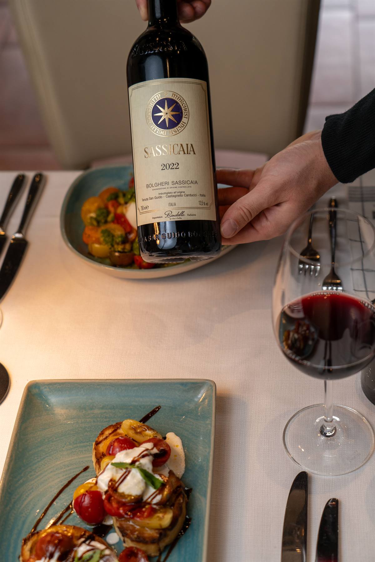 Eine Flasche Sassicaia wird am Tisch präsentiert