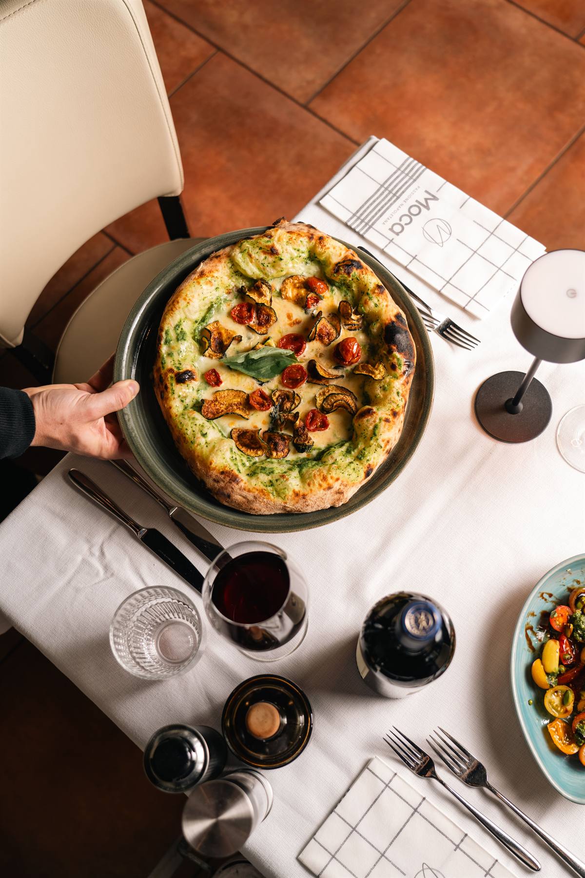 Pizza Del Contadino wird von Hand serviert